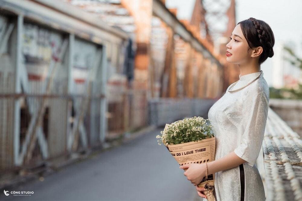 Mẫu mặc áo dài ôm hoa chụp tại lan can cầu Long Biên (Nguồn: Cộng Studio)